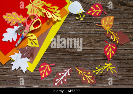 Autumn colored paper leaves on the wooden background. The child cuts out paper  leaves. Sheets of paper crafts for kids. Children Stock Photo - Alamy