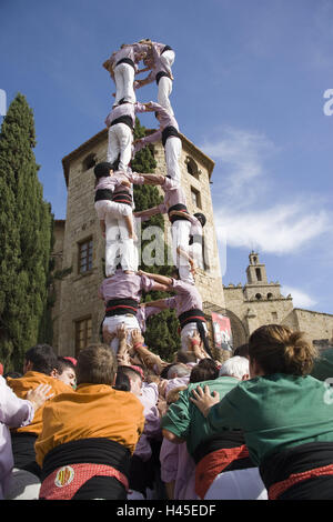 Spain, Sant Cugat del Valles, human tower, Catalonia, Castell, tourism, tradition, event, human pyramid, person, outside, pile up, tower, men, women, children, girls, heavens, clouds, blue, trees, stand, shoulders, climb, stick, church, save, hold, push, Stock Photo