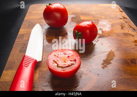 still life - ripe small tomatoes and knife on wooden background Stock Photo