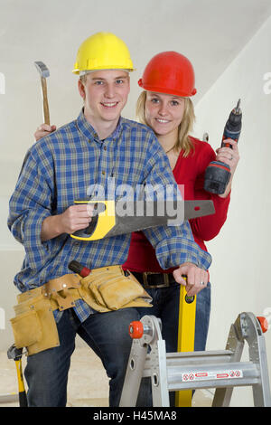 Couple, young, smile, construction helmets, tools, icon, do it yourself, person, upgrading, construction, men at work, build, roof upgrading, attic, DIY, do-it-yourselfer, happy, funnily, helmets, tool belts, howler, saw, battery power screwdriver, level, conductor, Stock Photo