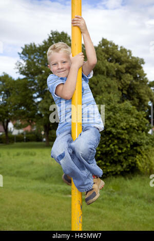 A boy, 5 years old, on a playground, climbs, stick, model release, Stock Photo