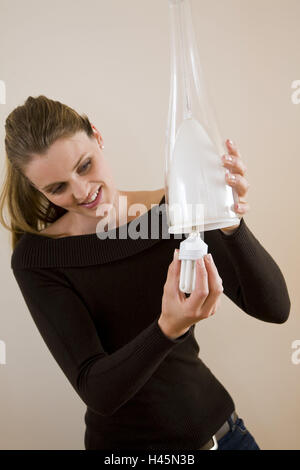 Woman, energy economy pear, lamp, change, energy, energy saving, energy economy lamp, light bulb, lamp, power consumption, cost reduction, electricity, Ecologically, light, shine, climate protection, person, inside, Hängelampe, ceiling lamp, compact fluor Stock Photo