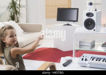 Living room, girl, gesture, long-distance-service, no property release, people, child, 6 years, childhood, TVs, lcd-TV-set, loudspeakers, Mac mini, iPod video, Apple Remote, electronics, electro-appliances, technology, conversation, conversation-electroni Stock Photo