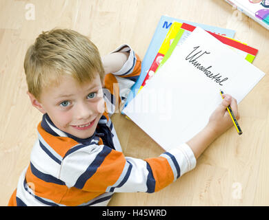Boy, floor, lie, add support head, write, block, portrait, Stock Photo