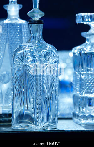Empty crystal bottles for liquor in blue tone. Vertical Stock Photo