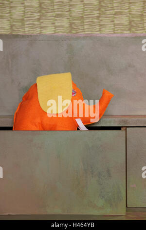 Orange stuffed elephant in a box. Vertical format Stock Photo