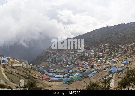 Nepal, Solo Khumbu, region Everest, the Himalayas, Namche bazaar, houses, from above, Central Asia, Khumbu region, mountain village, village, Namche, mountainside, tin roof, terraces, settlement, building, residential houses, trade, commercial space, tourism, trekking, accomodation, building boom, clouds, fog, Stock Photo