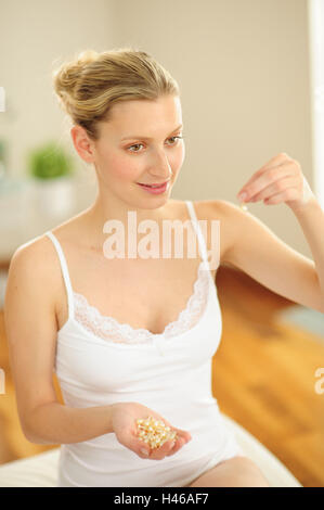 Young woman is holding capsules in the hand, Stock Photo