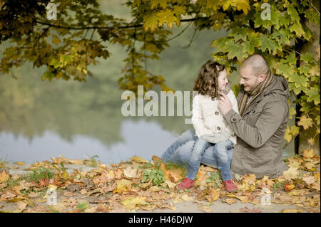 Subsidiary sits on lap the father, autumn foliage, Stock Photo