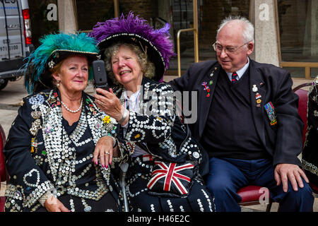 Two Pearly Queens Pose For A Selfie At The Pearly Kings and Queens' Harvest Festival, The Guildhall Yard, London, England Stock Photo
