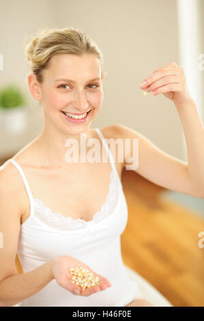 Young woman is holding capsules in the hand, Stock Photo