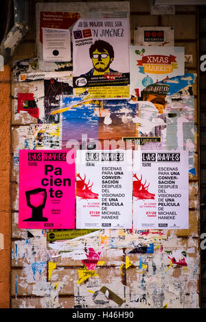 Torn Spanish posters overlaid with new posters on a wall Stock Photo