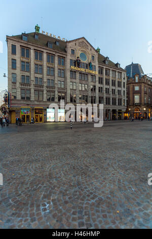 AMSTERDAM, NETHERLANDS - APRIL 4, 2008:Tourists walk in front of facade Madame Tussaud museum on Dam square Stock Photo