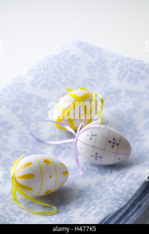Yellow and purple painted Easter eggs on blue tablecloth, Stock Photo