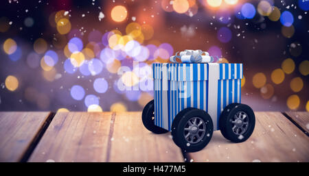 Composite image of digitally generated image of gift box with wheels Stock Photo