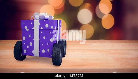 Composite image of gift box with gray ribbon on wheels Stock Photo
