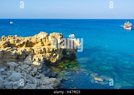 The small boats and tourist yachts come to the coast of Cape Greco to enjoy the views and relax, Cyprus. Stock Photo