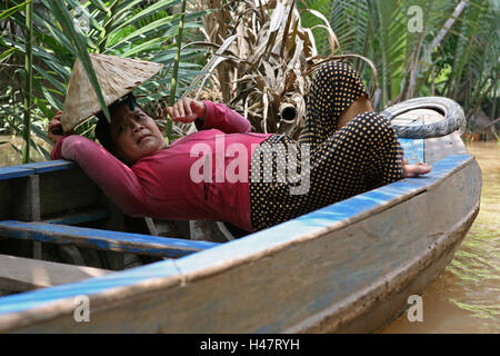 Woman relaxes in her canoe, backwater canal in the Mekong Delta, Tan An Thuong, Tan Thach, Chau Thanh, Ben Tre, Viet Nam Stock Photo