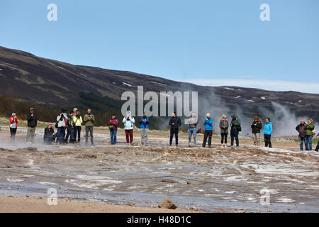 tourists stand around waiting for the strokkur geyser to erupt geysir Iceland Stock Photo