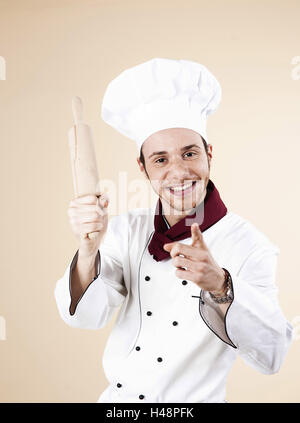 Cook, view camera, rolling-pin, threat, fun, portrait, person, man, young, studio, cooking cap, headgear, finger, gesture, interpret, culinary implement, smile, forefinger, Stock Photo