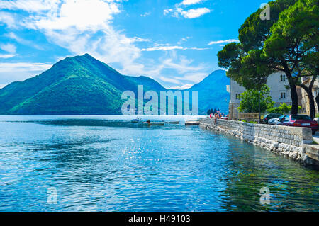 Nice views on high mountains around narrow bay, medieval architecture and bright blue sea makes Perast popular among tourists Stock Photo