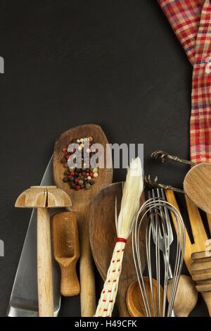 Kitchen utensils on wooden table. Tools cook. Needs to cook. Set of the wooden kitchen utensils on black wooden background. Stock Photo