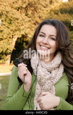Woman, holding MP3 player, smiling, portrait, Stock Photo