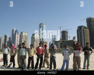 United Arab Emirates, Dubai, Jumeirah Beach, high rises, workers, group, stand, town, part town, hotels, hotel buildings, flatlets, high rises, architecture, skyline, tourism, destination, beach, person, men, outside, group picture, cranes, Stock Photo