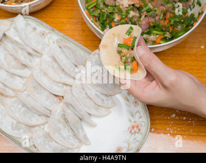 lady making dumplings at home Stock Photo