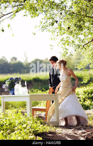 Bride and groom standing in front of table in the nature Stock Photo