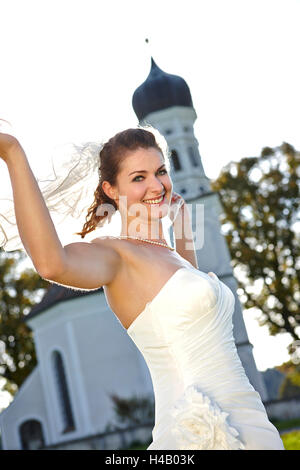 Bride with bridal bouquet in front of church Stock Photo