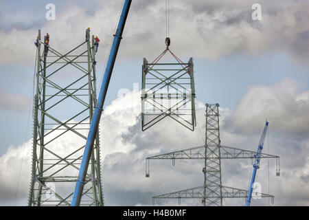 High-voltage pole, installation, men waiting for a pole component lifted by a crane, Thuringian Forest Stock Photo