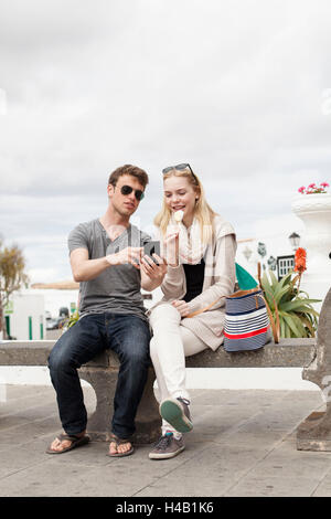 Friend showing something on the mobile phone to his girlfriend Stock Photo