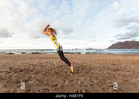 Nudist woman jogging on the beach. Canary Island Fuerteventura, Spain