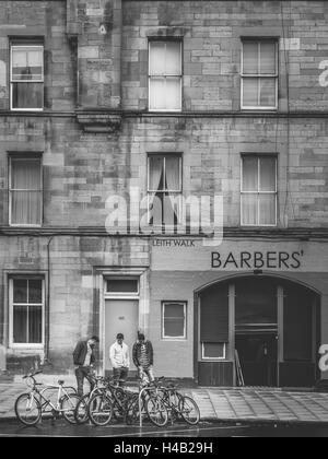 Edinburgh, Scotland -  02 September 2016 : Three man looking at parked bicycles in front of a barber shop in Leith in Edinburgh, Stock Photo