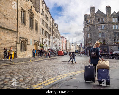Edinburgh, Scotland -  02 September 2016 : Woman pulling luggage suitcases and tourists on the street in the Edinburgh Old Town Stock Photo