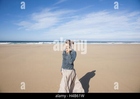 Woman calls up on the beach, Stock Photo