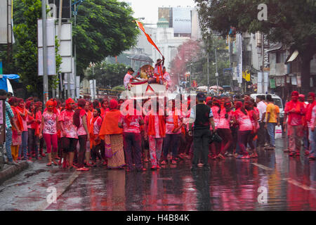 Group of young Indian boys and girls celebrating Ganpati procession with Gulal (red powder), pune Stock Photo