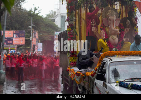 Ganesh idol with group of young Indian boys and girls during Ganpati procession , pune Stock Photo