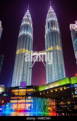 Lighted Petronas Towers with colored fountain at night, Kuala Lumpur, Malaysia Stock Photo