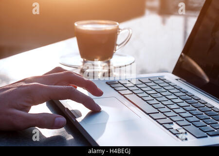 Woman using laptop with a cup of coffee Stock Photo