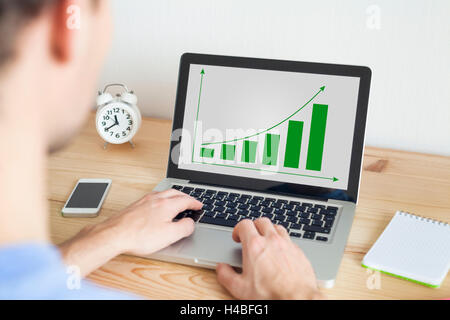 Businessman working at home on laptop and smartphone on sustainable development project Stock Photo