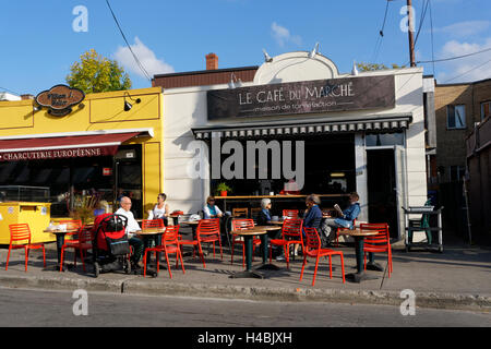 People sitting at tables outside the the Cafe de la Marche next to the Jean Talon Market, Montreal Quebec, Canada Stock Photo