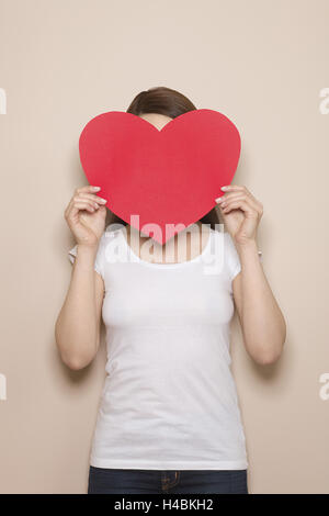 Woman, young, face hidden behind a heart, half portrait, Stock Photo