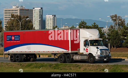 A Canada Post semi tractor trailer transport truck travels along a road, Richmond, British Columbia, Canada. Stock Photo