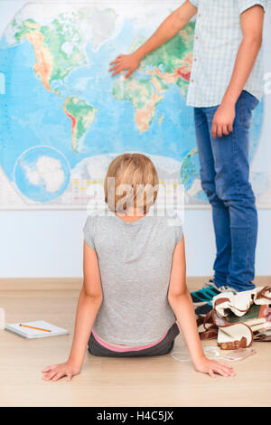 Teenagers sitting by the map in classroom Stock Photo