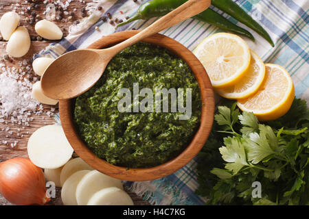 Chimichurri sauce with ingredients close-up on the table. horizontal view from above Stock Photo