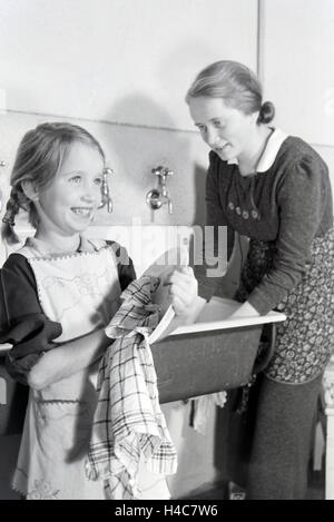 Mitglieder einer kinderreichen Familie bei der Hausarbeit, Deutsches Reich 1930er Jahre. Members of a extended family doing the housework, Germany 1930s Stock Photo