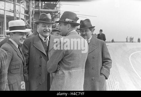 Der deutsche Ingenieur Ferdinand Porsche (rechts) im Gespräch mit Kollegen an der AVUS Rennstrecke in Berlin, Deutschland 1930er Jahre. German engineer and inventor Ferdinand Porsche (right) talking to colleagues at Berlin AVUS race track, Germany 1930s Stock Photo