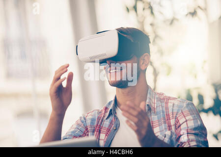 Entrepreneurs testing virtual reality technology with colleague in office. Stock Photo